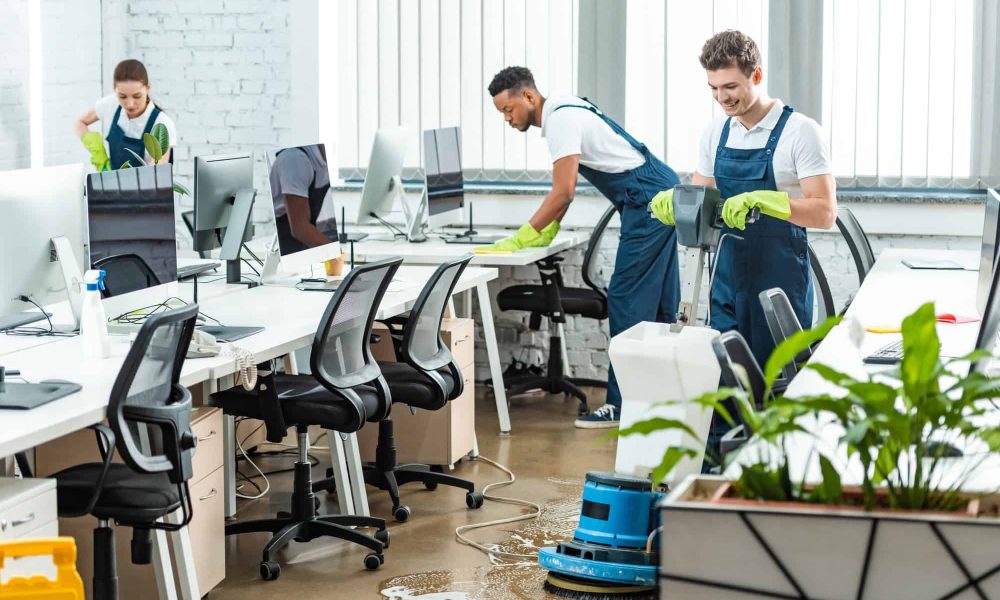 multicultural team of cleaners working in modern open space office